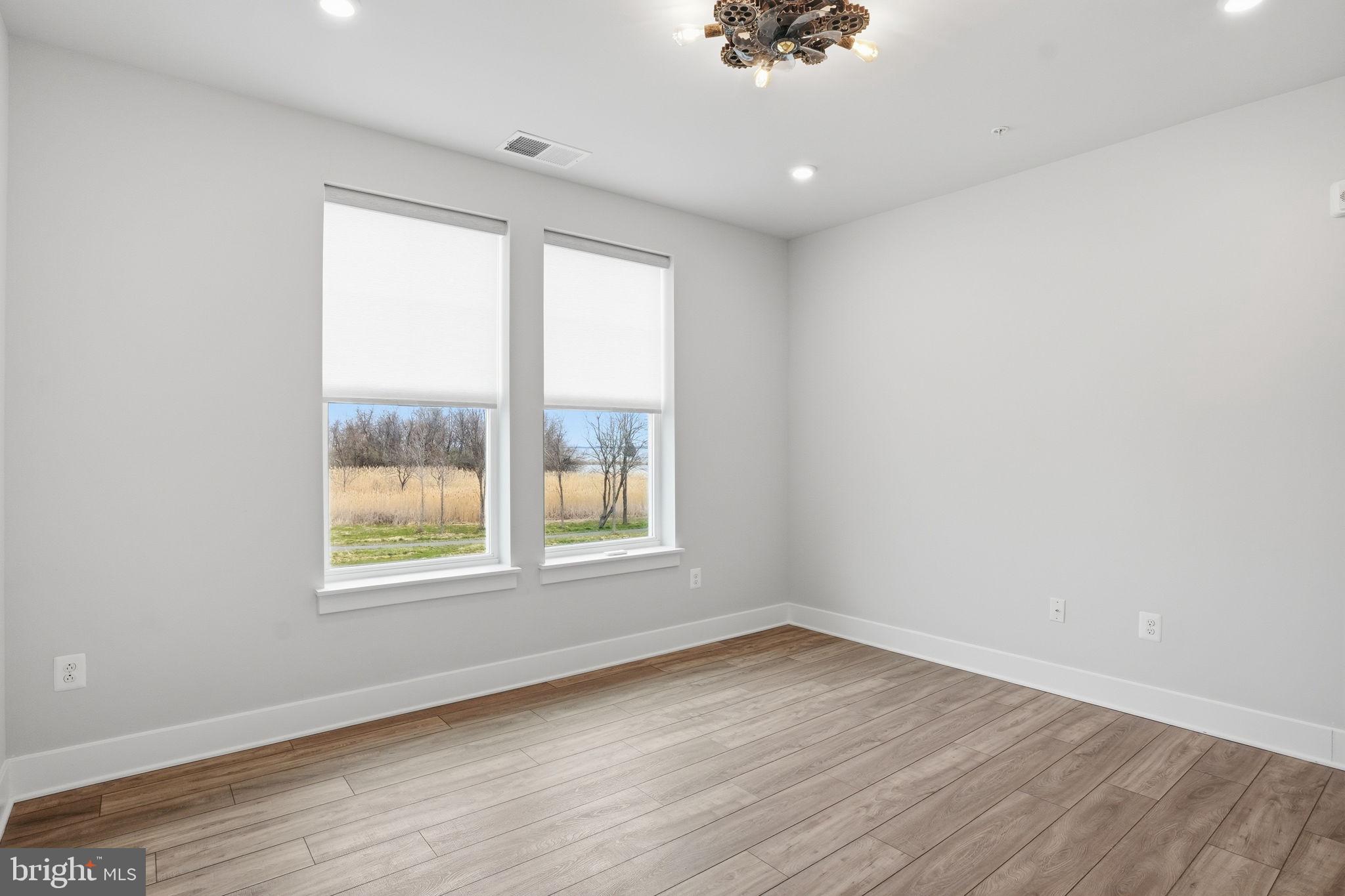 111 Marshgrass Way, Unit 22 Chester, MD 21619 - Photo 24 of 102 an empty room with wooden floor and windows