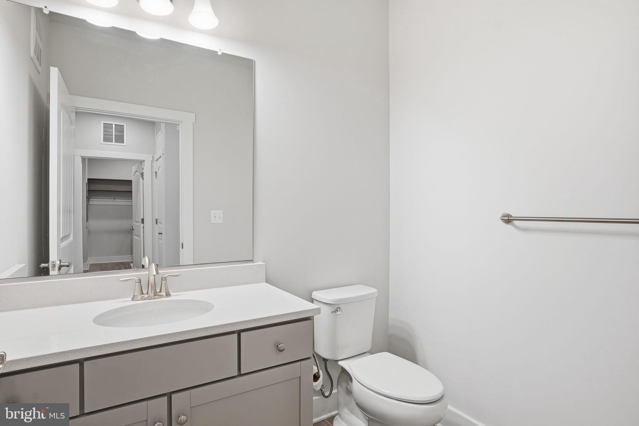 111 Marshgrass Way, Unit 22 Chester, MD 21619 - Photo 27 of 102 a bathroom with a sink toilet and mirror