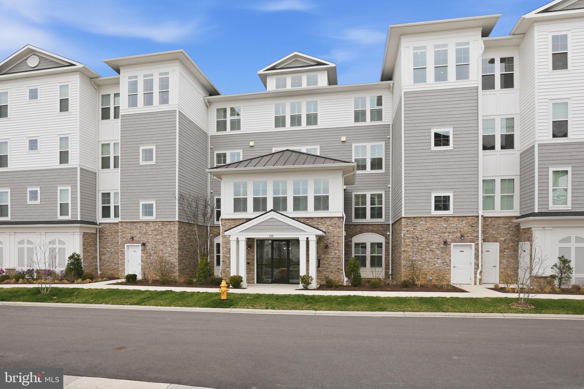 111 Marshgrass Way, Unit 22 Chester, MD 21619 - Photo 3 of 102 a front view of a residential apartment building with a yard