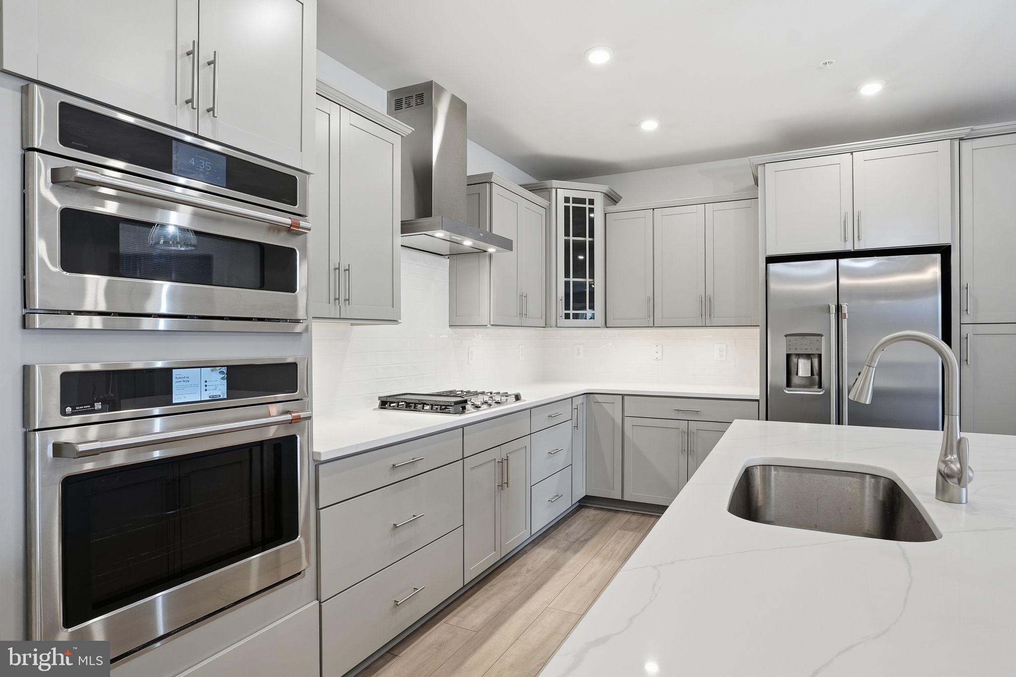 111 Marshgrass Way, Unit 22 Chester, MD 21619 - Photo 8 of 102 a kitchen with stainless steel appliances kitchen island granite countertop a stove and a sink