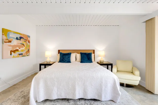 a bedroom with a bed and a painting on the wall