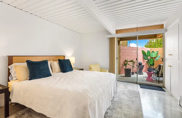 a large bed sitting in a bedroom next to a window
