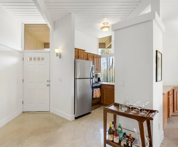 a view of a kitchen with refrigerator and wooden floor