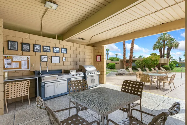 a open kitchen with stainless steel appliances granite countertop a stove a refrigerator a dining table and chairs with the outer view