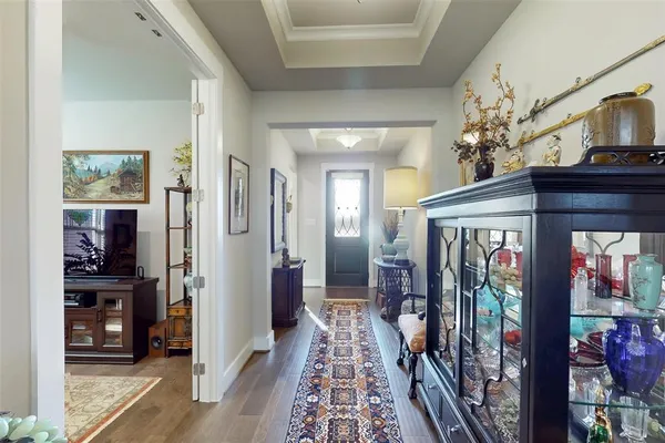 a view of a hallway with furniture and chandelier