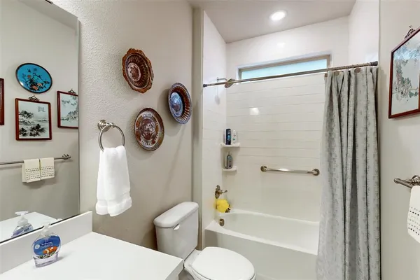 a white toilet sitting next to a bath tub and a shower
