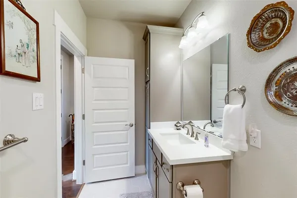 a bathroom with a sink a light fixture and a mirror