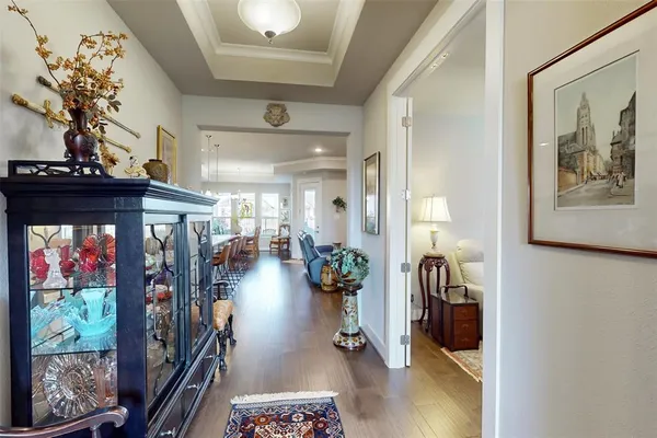 a view of a hallway and a dining room with chandelier