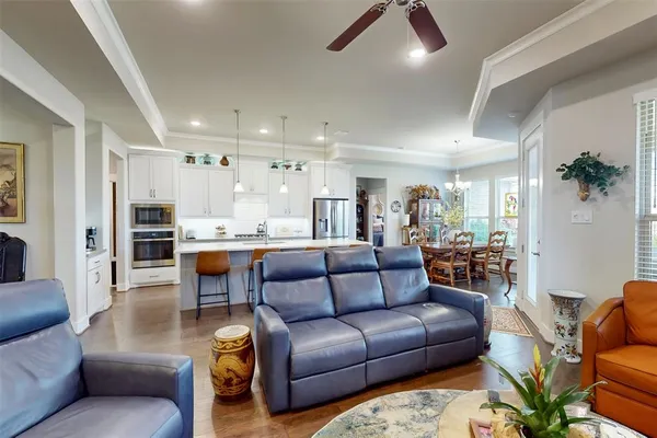 a living room with furniture kitchen view and a chandelier