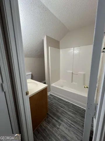 a view of an empty room with a chandelier fan