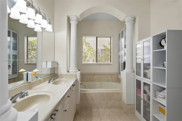 a bathroom with a tub sink and mirror