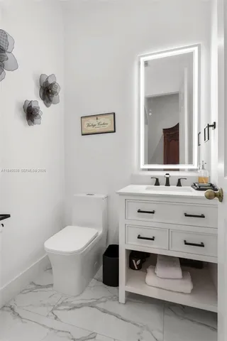 a bathroom with a sink mirror and toilet