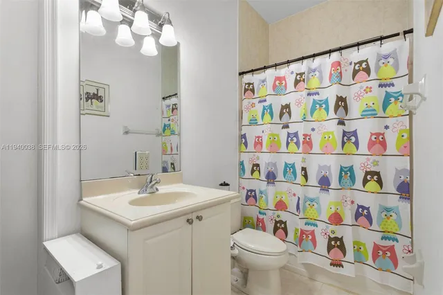 a bathroom with a sink a toilet and a shower curtain