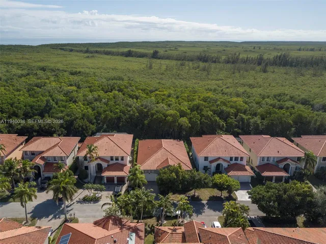 an aerial view of residential houses with outdoor space and trees