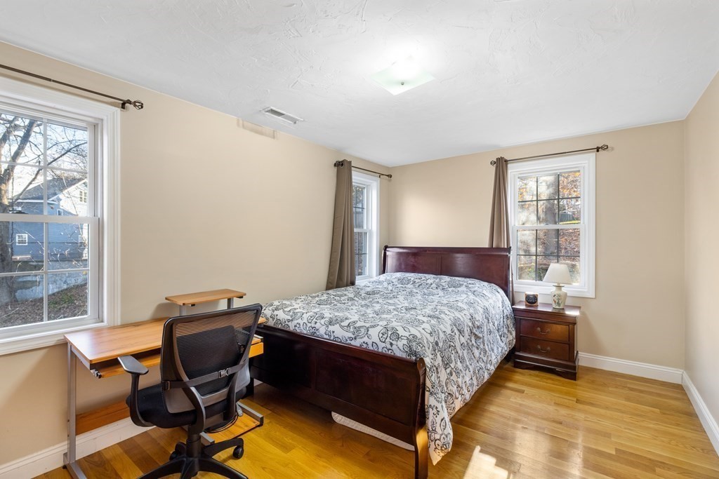 11 Spring Road, Unit B Arlington, MA 02476 - Photo 11 of 19 a bedroom with a bed and wooden floor