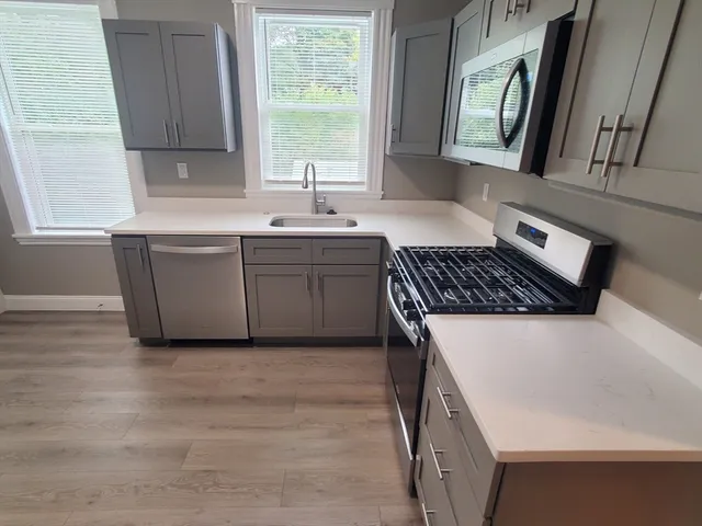 a kitchen with granite countertop a sink cabinets and window