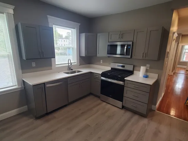 a kitchen with sink a microwave and cabinets