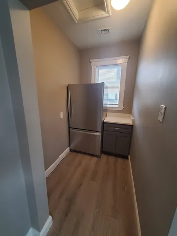 a view of a kitchen with wooden floor and electronic appliances