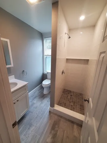a bathroom with a granite countertop sink toilet and shower