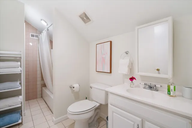 a spacious bedroom with a bed and a lamp