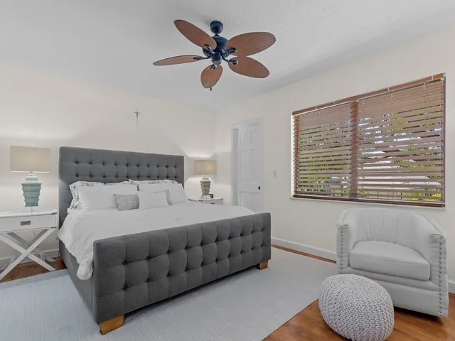 a bedroom with a bed a couch and a large window