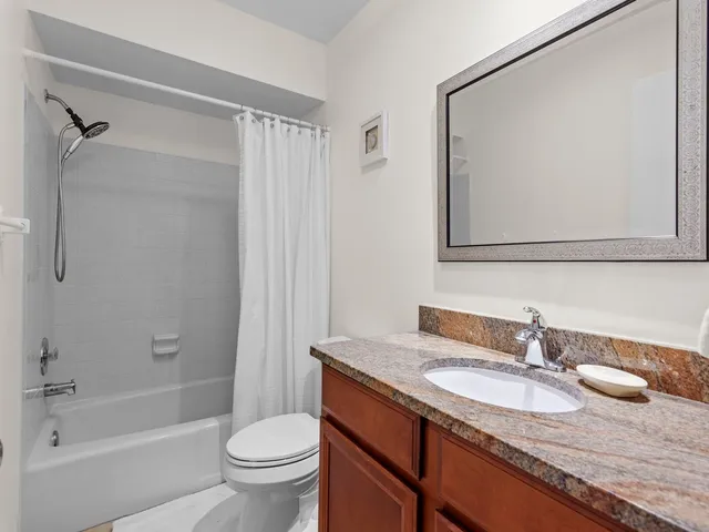 a bathroom with a granite countertop sink a toilet and a bathtub
