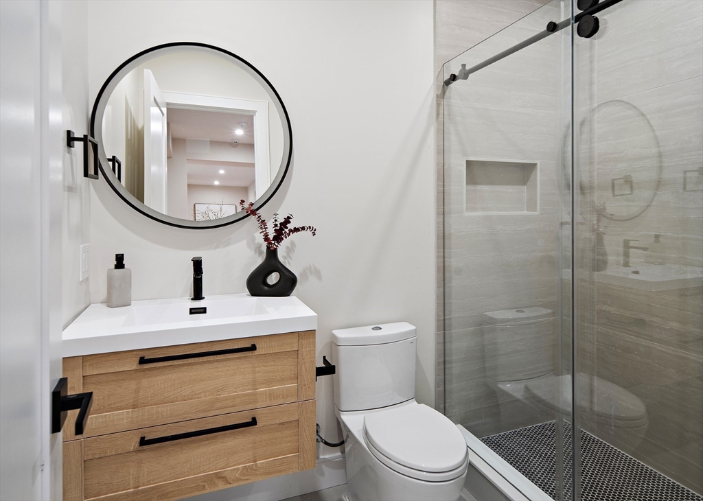 34 Pershing Road Needham, MA 02494 - Photo 33 of 41 a bathroom with a sink a toilet and a mirror