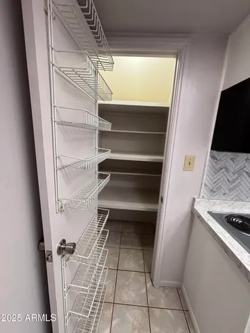 a view of walk in closet with empty racks