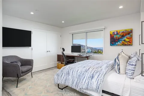 a bedroom with a bed a couch and a flat screen tv