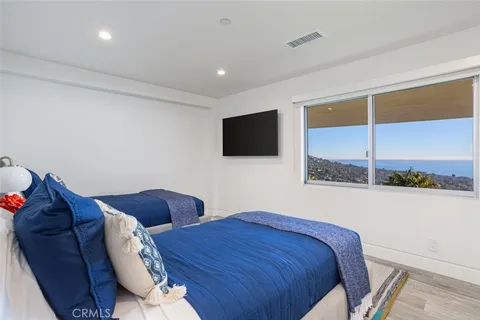 a bedroom with two beds and a flat screen tv