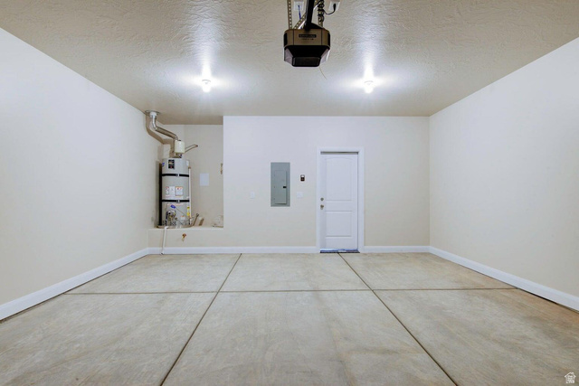 668 East Fiddlers Canyon Road, Unit 24 Cedar City, UT 84721 - Photo 16 of 21 Garage with electric panel, strapped water heater, and a garage door opener