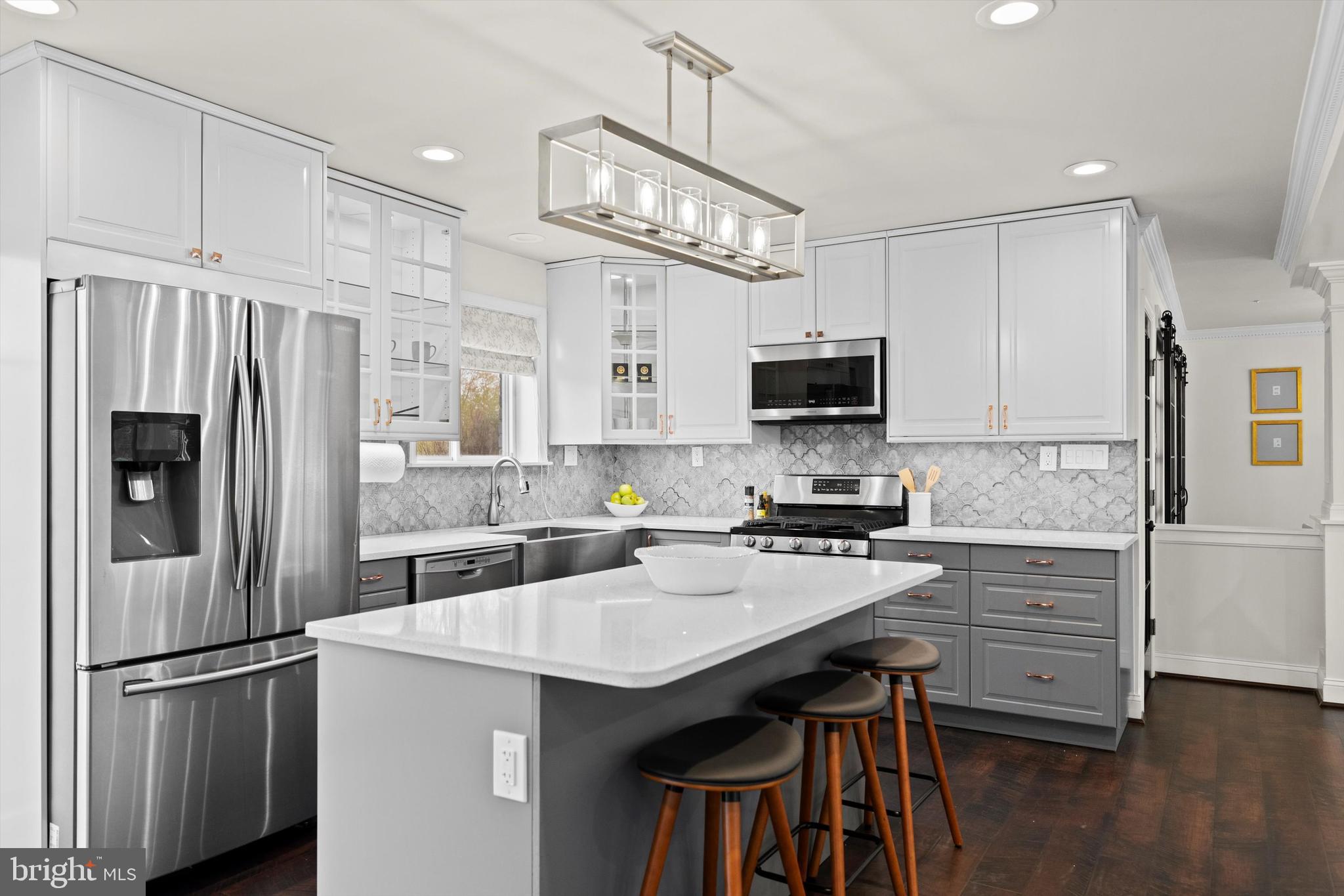 3206 North Glebe Road Arlington, VA 22207 - Photo 5 of 20 a kitchen with granite countertop a refrigerator stove and microwave with wooden floor