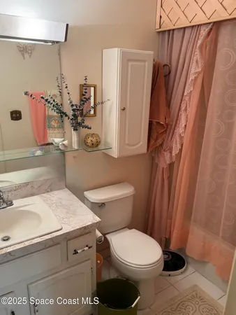 a bathroom with a granite countertop toilet sink and mirror