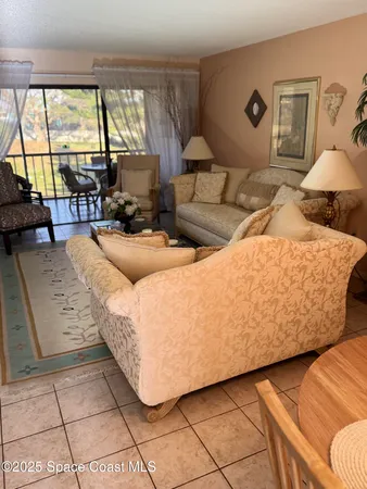 a living room with furniture and a floor to ceiling window