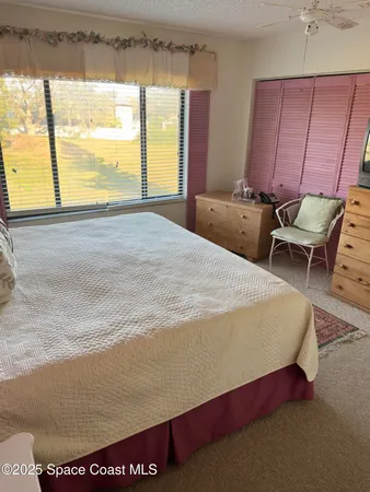 a bed sitting in a bedroom next to a window