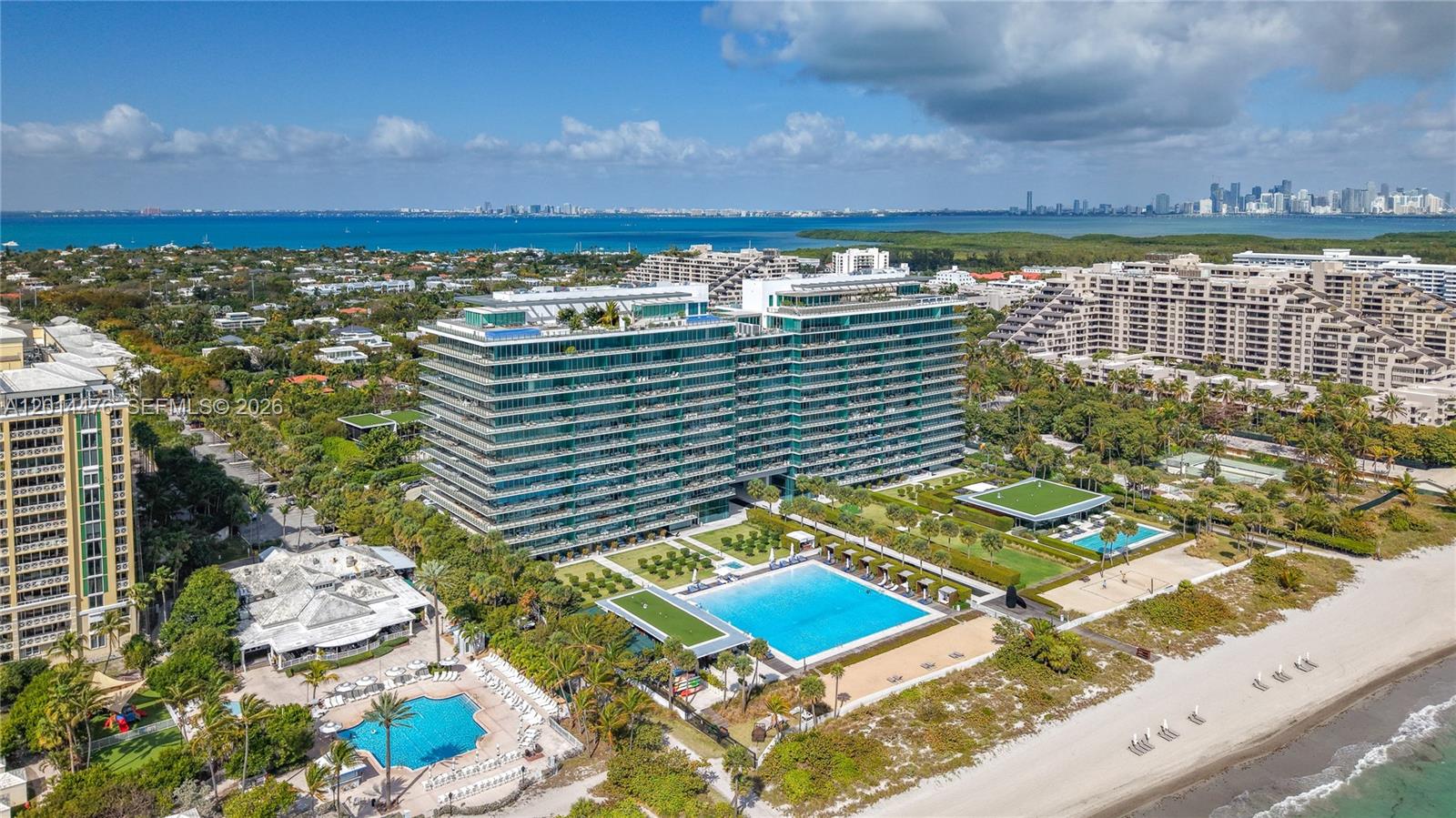 360 Ocean Drive, Unit 1106S Key Biscayne, FL 33149 - Photo 48 of 67 Aerial Oceanfront Community View – A wide aerial perspective highlights the building, beach, pool areas, and surrounding coastal community. The view captures both the oceanfront setting and the broader island landscape.
