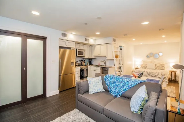 a living room with furniture and kitchen view