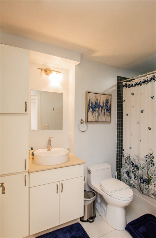 22 Hancock Street, Unit 102 Boston, MA 02114 - Photo 5 of 5 a bathroom with a sink mirror vanity and toilet