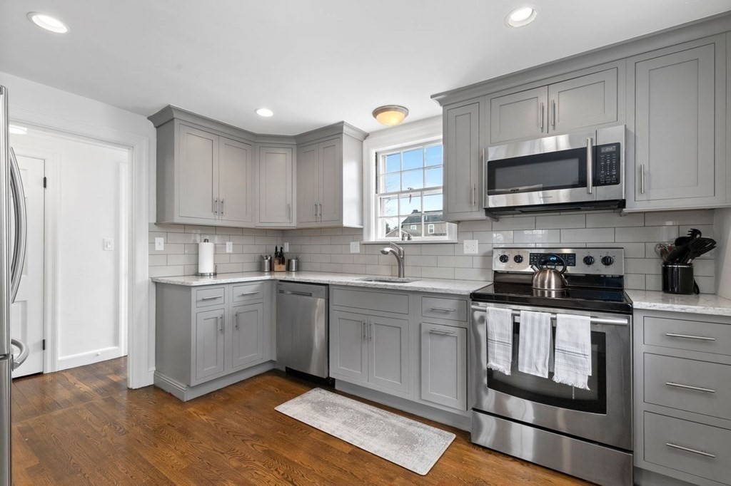 10 Standish Road Milton, MA 02186 - Photo 9 of 28 a kitchen with stainless steel appliances granite countertop a stove a sink and a microwave