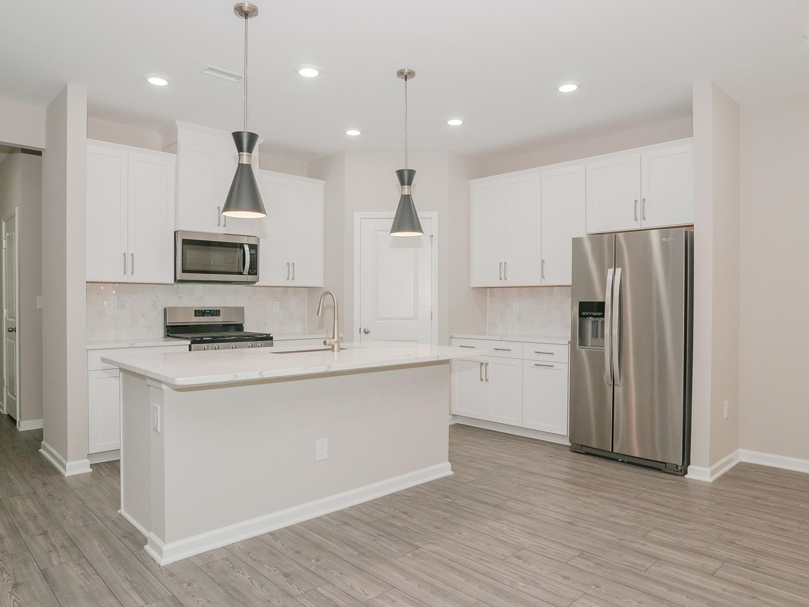 4001 Mountjoy Trail Raleigh, NC 27616 - Photo 16 of 59 a kitchen with a refrigerator a stove top oven a sink and a wooden floor