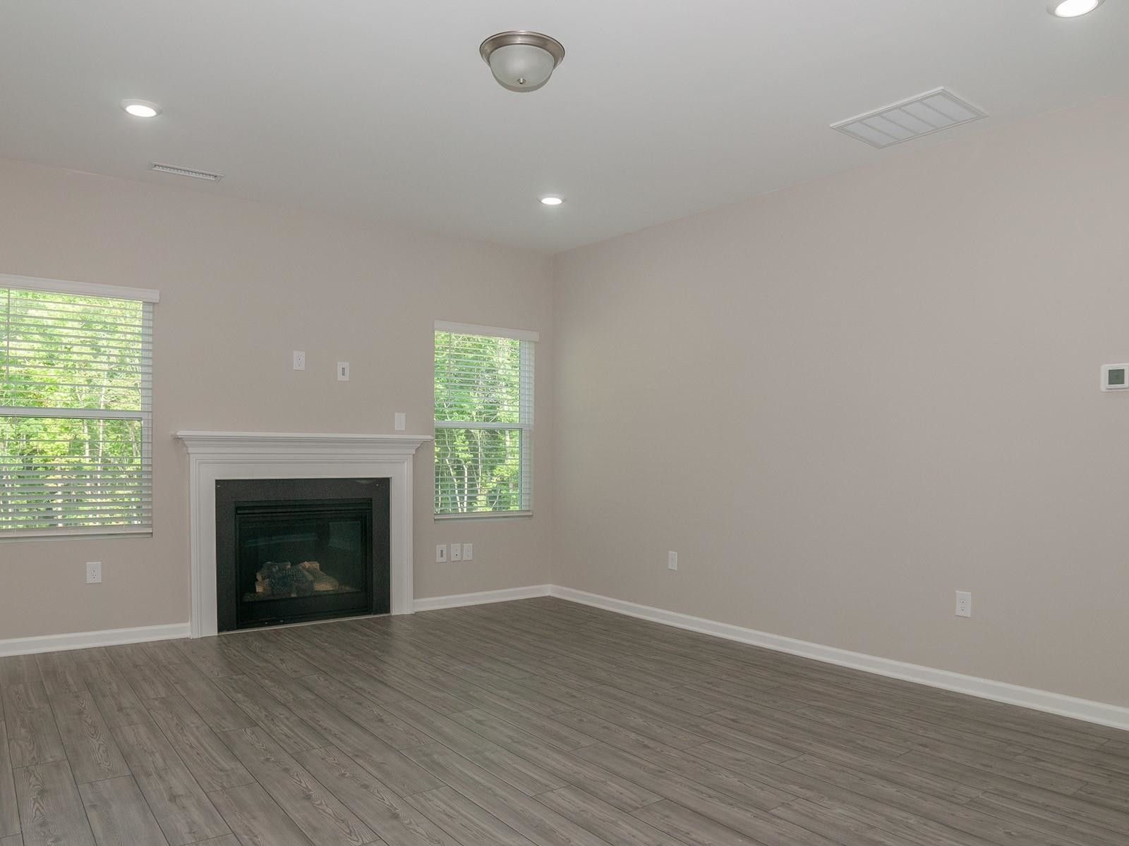 4001 Mountjoy Trail Raleigh, NC 27616 - Photo 9 of 59 an empty room with wooden floor fireplace and windows
