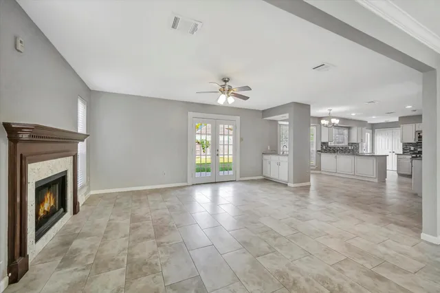 a view of an empty room with a fireplace and window