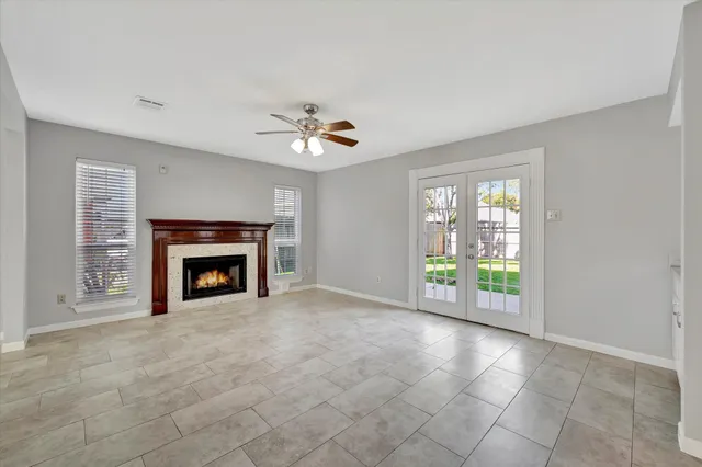 an empty room with windows and fireplace