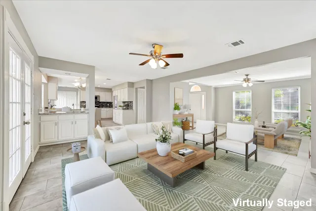 a living room with furniture kitchen view and a chandelier