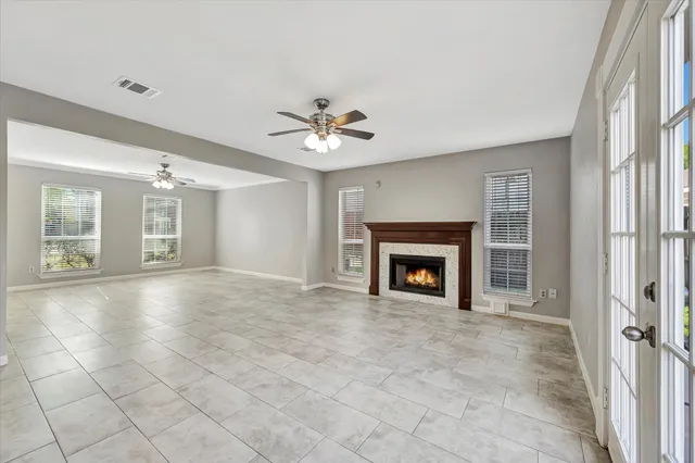 a view of an empty room with a fireplace and a window