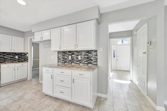 a kitchen with granite countertop a sink and cabinets