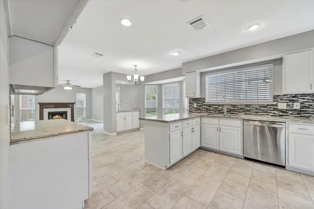 a kitchen with granite countertop cabinets stainless steel appliances a sink and a window