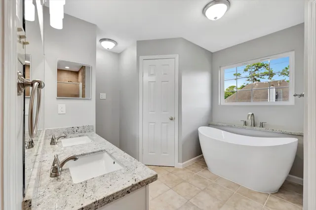 a spacious bathroom with a granite countertop sink a mirror and a shower