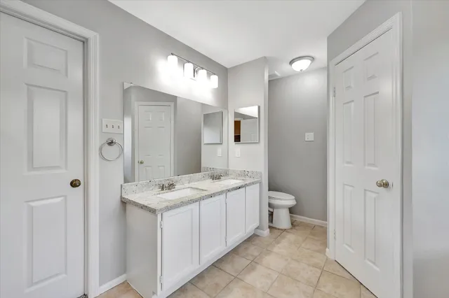 a bathroom with a granite countertop sink double vanity and a mirror