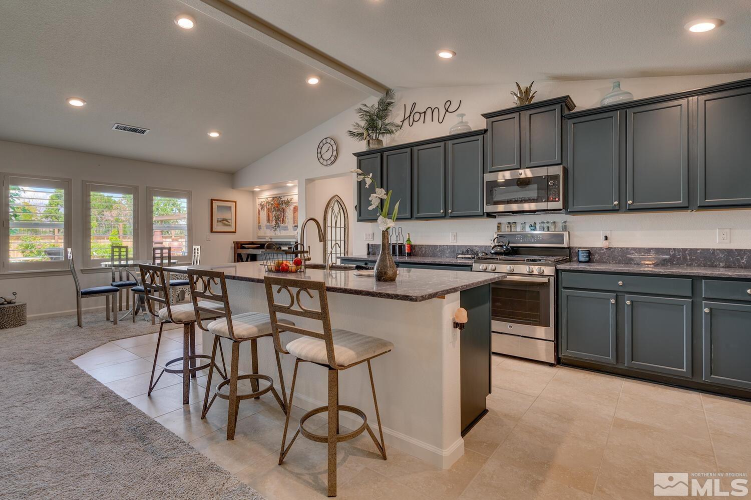 148 Carson River Drive Dayton, NV 89403 - Photo 6 of 31 a kitchen with stainless steel appliances kitchen island granite countertop a stove a sink a refrigerator and chairs